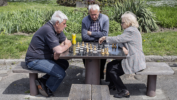 暖かい春の日に公園でチェスを楽しむ老人たち