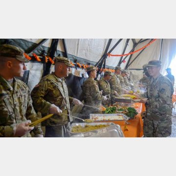 感謝祭の食事を配る陸軍兵士ら