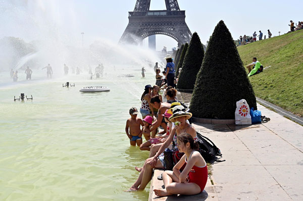 欧州で熱波が続き独仏で42度、 エッフェル塔を望むトロカデロ庭園の池で涼む人々