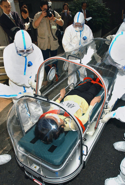 新型肺炎（SARS）の再流行に備えカプセル型の専用車を使って患者の搬送訓練をする保健所職員（2003年）／