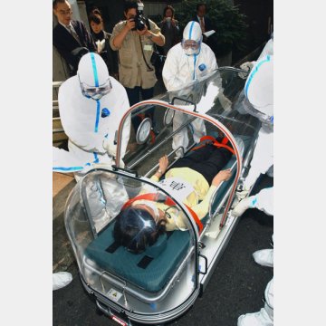 新型肺炎（SARS）の再流行に備えカプセル型の専用車を使って患者の搬送訓練をする保健所職員（2003年）／