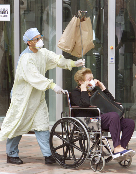 2003年、カナダでSARSが流行し273人が感染した（退院するSARS高齢患者を、彼女の車まで付き添う防護服の病院従業員）