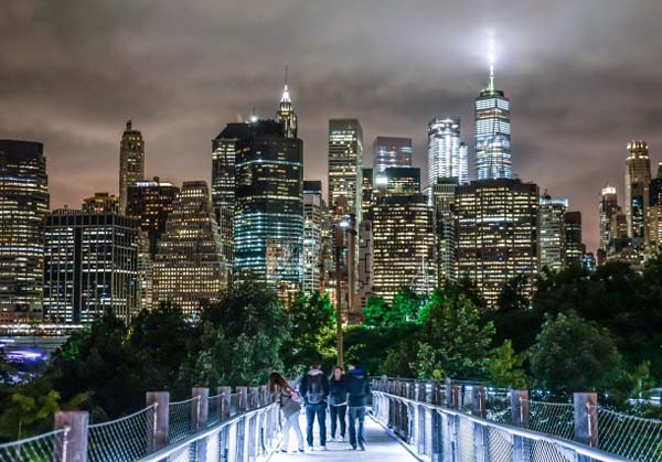 ニューヨークの夜景が見える公園を歩く若者たち