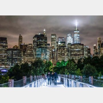 ニューヨークの夜景が見える公園を歩く若者たち