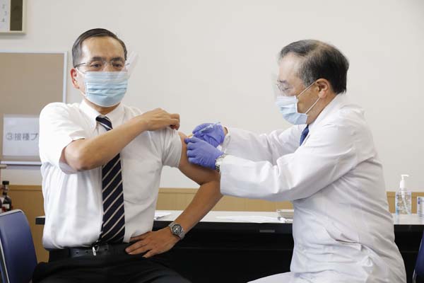国内1例目のワクチン接種を受ける、国立病院機構東京医療センターの新木一弘院長（左）／