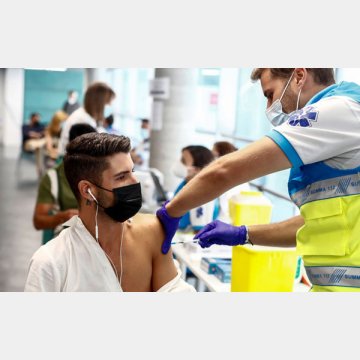 新型コロナウイルスワクチンの接種を受ける若い男性（スペイン）／