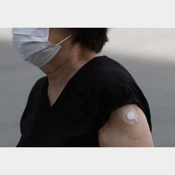 新型コロナワクチンの接種を終え会場を出る女性