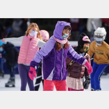 マスクを着けてブライアント公園でスケートを楽しむ子供たち