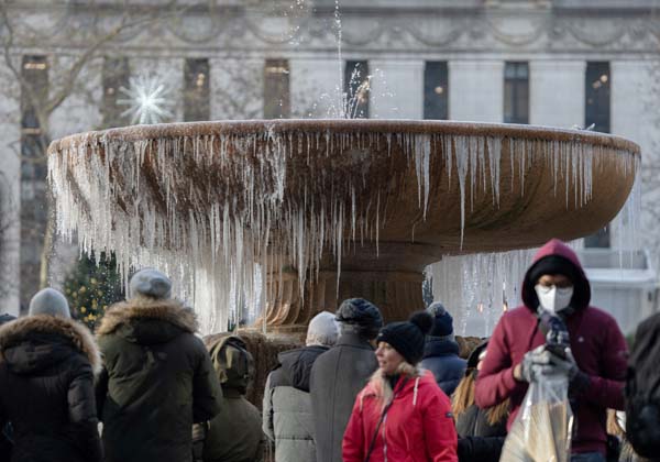 クリスマス・イブの日、ブライアント・パークの凍った噴水の前に立つ人々（米ニューヨーク）／（Ｃ）ロイター