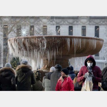 クリスマス・イブの日、ブライアント・パークの凍った噴水の前に立つ人々（米ニューヨーク）／（Ｃ）ロイター