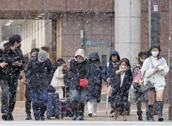 雪が降る中、福岡・天神の繁華街を歩く人たち（Ｃ）共同通信社